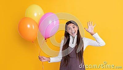 happy child with party helium balloons on yellow background Stock Photo