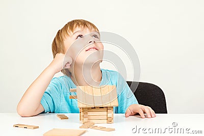 Happy child playing and building wooden home. Childhood dreams. Little boy builds his dream house. Happy life, house or mortgage Stock Photo