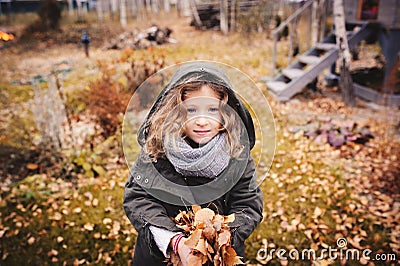 Happy child playing with leaves in autumn. Seasonal outdoor activities with kids Stock Photo