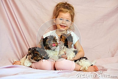 Happy child playing with puppies. Girl with the dogs. Children and animals. Stock Photo