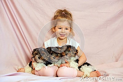 Happy child playing with puppies. Girl with the dogs. Children and animals. Stock Photo