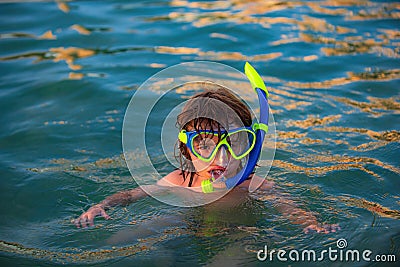 Happy child playing in the sea. Kid snorkeling in the ocean. Stock Photo