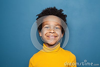 Happy child portrait. Little african american kid boy on blue background Stock Photo