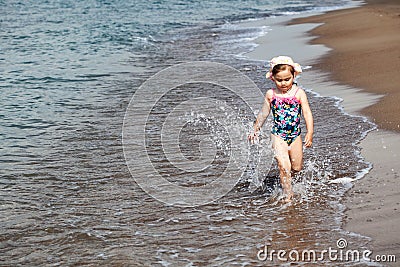 Happy child running and jumping in the waves Stock Photo