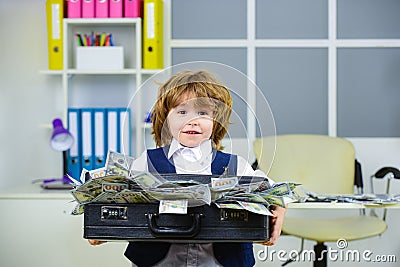 Happy child and a suitcase of money. Dollars, deposit, financial investments. Stock Photo