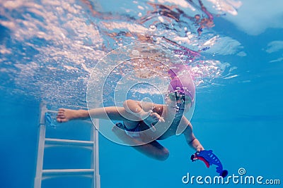 Happy child is trained to dive in the pool Stock Photo