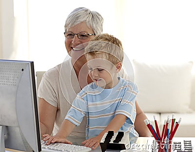 Happy child using a labtop with his grandmother Stock Photo