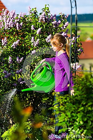 Happy child watering flowers in the garden Stock Photo