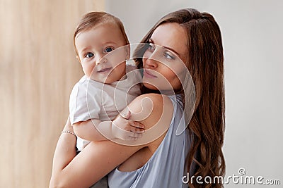 Happy childhood. Attractive Mother loves her adorable son, and small child looking at the camera with his blue eyes Stock Photo