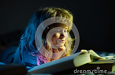 Happy childhood, dreaming child. Children reading a books. Kids bedtime, boy reading a book in bed. Stock Photo