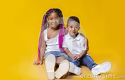 Cute little afro brother and sister sitting on floor and cuddling Stock Photo