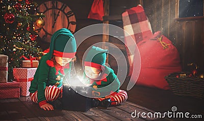 happy children brother and sister elf, helper of Santa with Christmas magic gifts Stock Photo