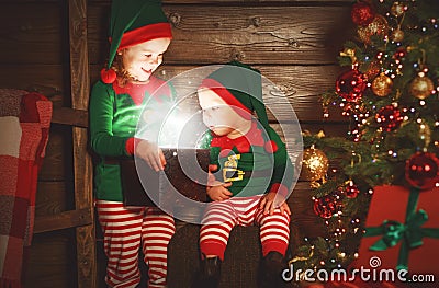 happy children brother and sister elf, helper of Santa with Christmas magic gifts Stock Photo