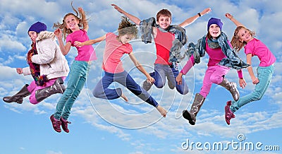 Happy children exercising and jumping in the blue sky Stock Photo