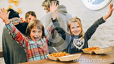 Happy children having fun while eating spaghetti pasta Stock Photo