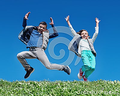 Happy children jumping on meadow Stock Photo