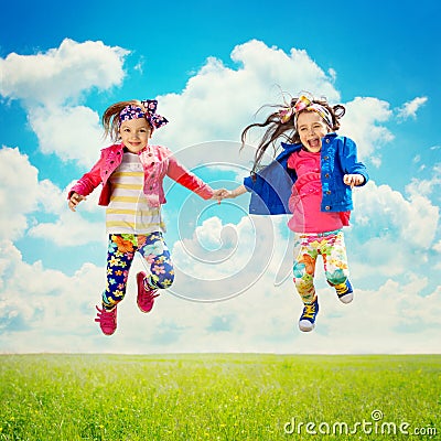 Happy children jumping on the spring field Stock Photo