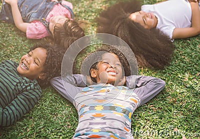 Happy children kids laying on grass in park. Stock Photo