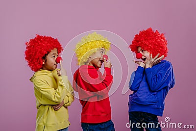 Happy children playing on clowns, studio shoot. Stock Photo