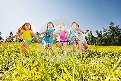 Happy children playing football in yellow meadow Stock Photo