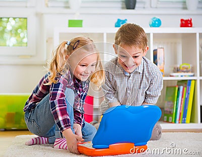 Happy children playing with laptop at home Stock Photo
