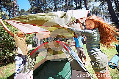 Happy children, portrait and tent setup in camping forest for shelter, cover or insurance together on the grass in Stock Photo