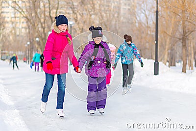 Happy children skating on the ice track in the park Editorial Stock Photo