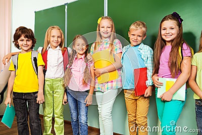 Happy children stand with text books in row Stock Photo