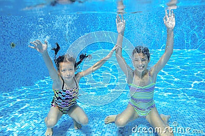 Happy children swim in pool underwater, girls swimming Stock Photo