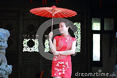Happy Chinese bride in red cheongsam at traditional wedding day Stock Photo