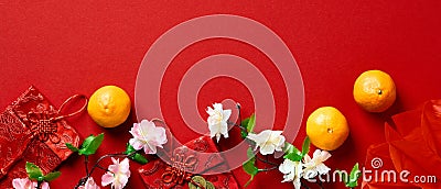 Happy Chinese New Year banner with tangerines, money envelopes, flowers on red table Stock Photo