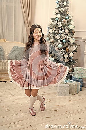 Happy Christmas girl. Little girl with xmas look. Small girl at Christmas tree. New year eve. Holiday celebration Stock Photo
