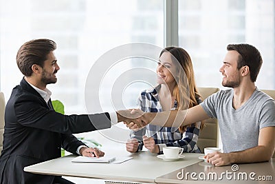 Happy clients couple handshake lawyer thanking for help Stock Photo