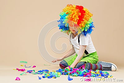 Happy clown boy with large colorful wig. Let`s party! Funny kid Stock Photo