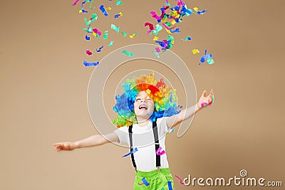 Happy clown boy with large colorful wig. Let`s party! Funny kid Stock Photo