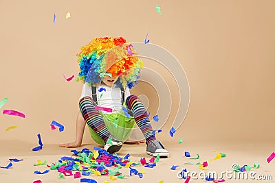 Happy clown boy with large colorful wig Stock Photo