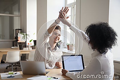 Happy colleagues giving high five satisfied with high results Stock Photo