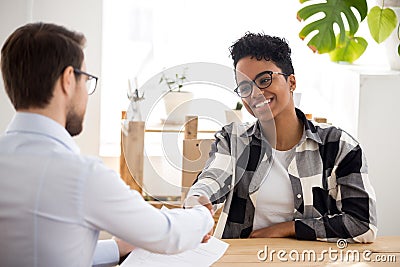 Happy confident african applicant shaking hand of hr getting hired Stock Photo