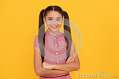 Happy confident child smile holding arms crossed yellow background, confidence Stock Photo