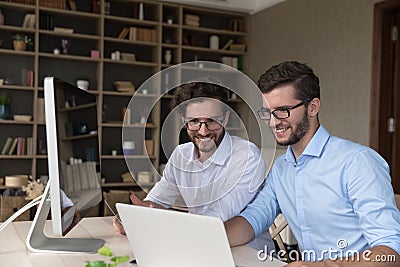 Happy confident twins in glasses working on family startup Stock Photo