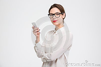 Happy confident young business woman in glasses using smartphone Stock Photo