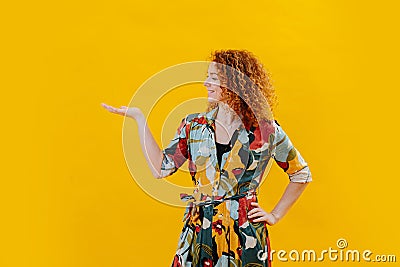 Happy confident young woman posing sideways, turning palm of her hand up. Stock Photo