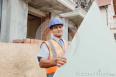 Happy constructor standing outside behind empty cardboard with copy text space. Stock Photo