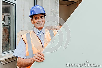 Happy constructor standing outside behind empty cardboard with copy text space. Stock Photo