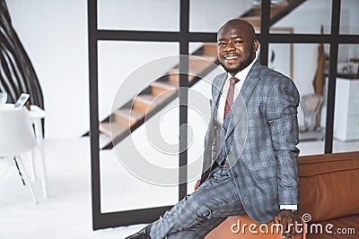 Happy And Contented Businessman. African American Man Smiling And Looking At Camera In Loft Apartment. Concept Of Rich Stock Photo