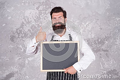 Happy cooking in kitchen. restaurant chef cuisine. brutal bearded man with blackboard. hipster cook or barista show Stock Photo