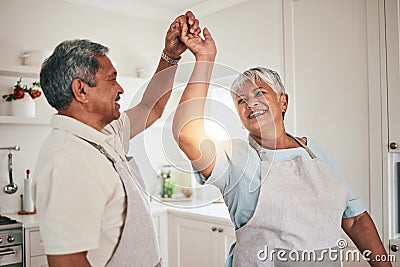 Happy, cooking and senior couple dancing in the kitchen together and feeling love, excited and bonding in home. Care Stock Photo