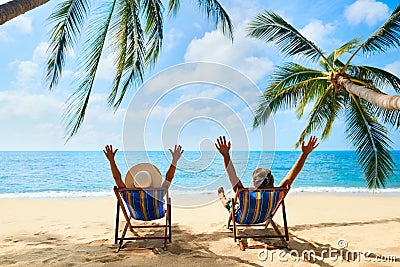 Happy couple with arms up relax on the beach enjoy beautiful sea on the tropical island Stock Photo