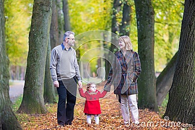 Happy couple in autumn park with toddler girl Stock Photo