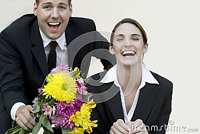 Happy couple in business suits with bouquet Stock Photo